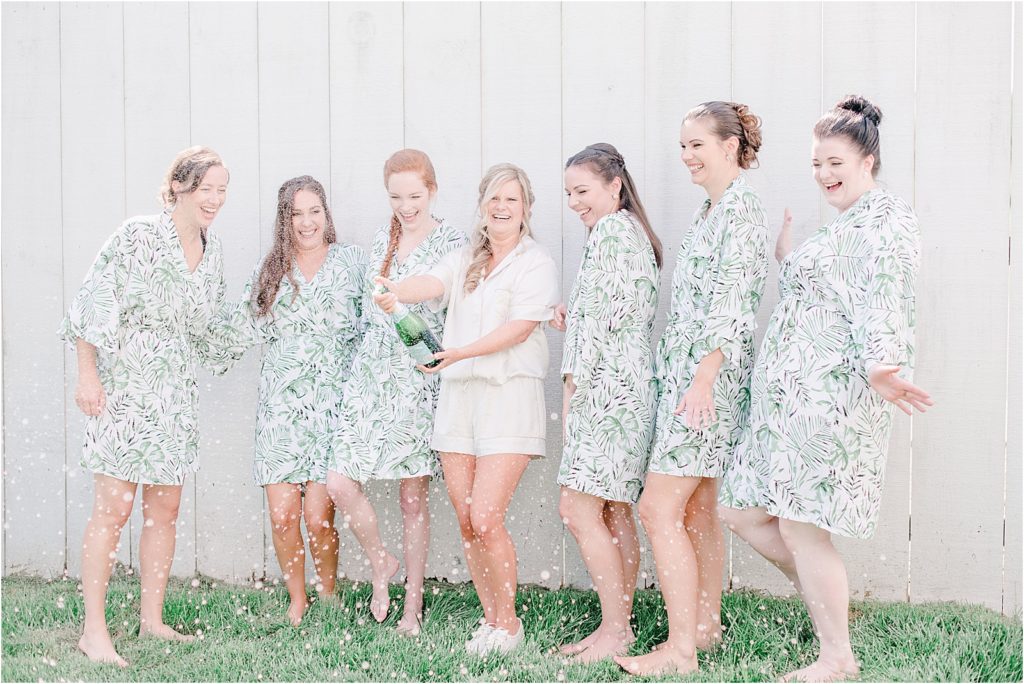 bridal party popping champagne