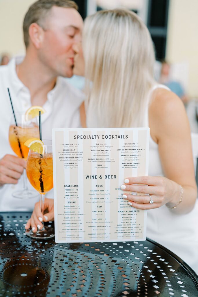 Couple sharing an Aperol spritz during their Cape May engagement session