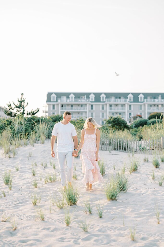 Cape May engagement couple walking along the shore at sunset