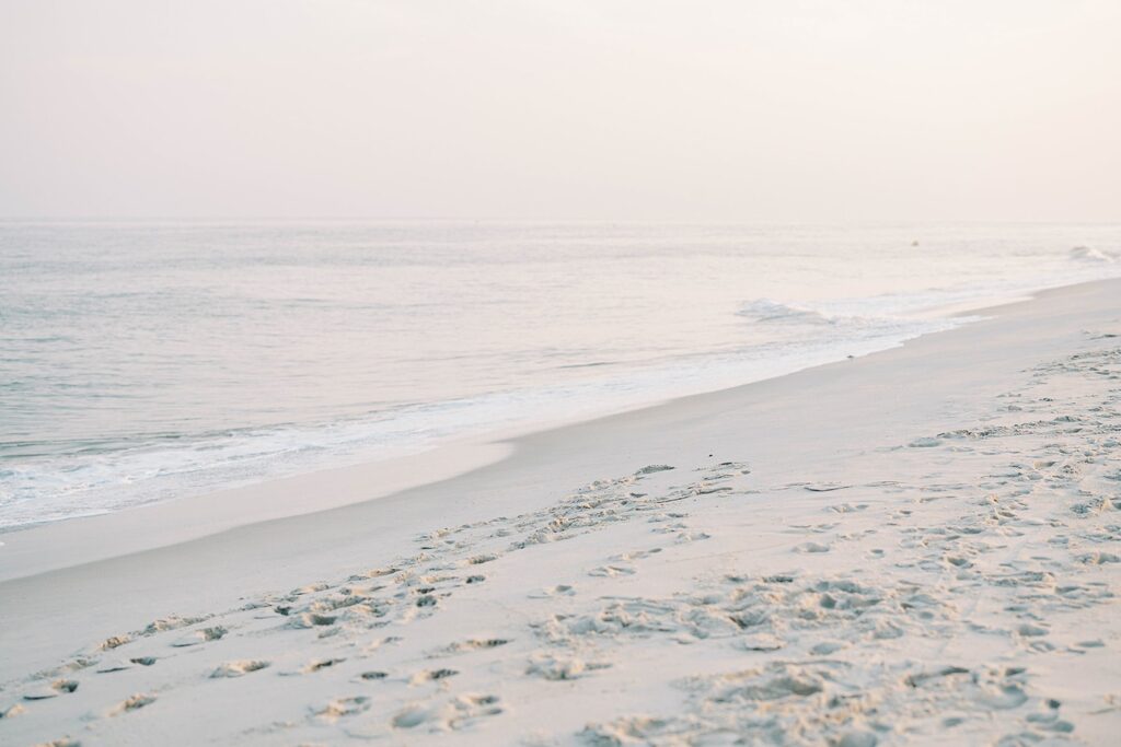 Cape May engagement couple walking along the shore at sunset