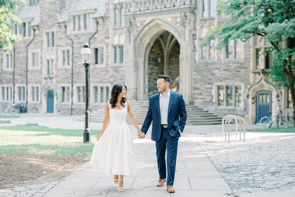 Couple holding hands under the arches during Princeton University NJ engagement session