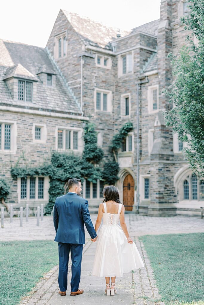 Bride-to-be and fiancé walking near ivy-covered walls at Princeton University