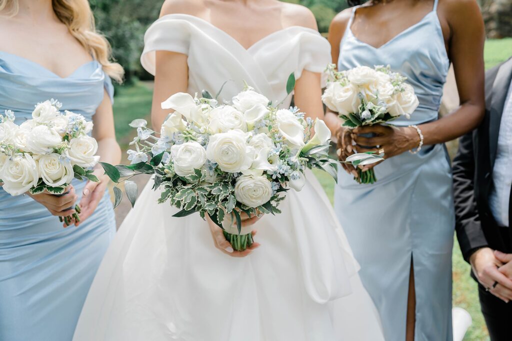 Bridesmaids in soft blue, groomsmen in black tuxedos.