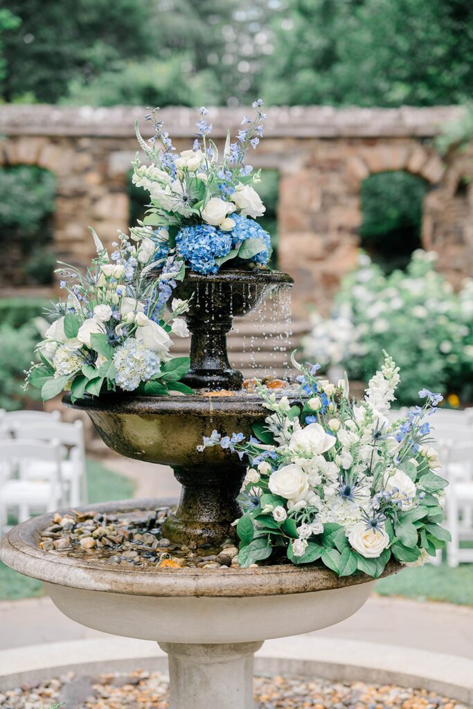 Garden ceremony by fountain with cascading florals.