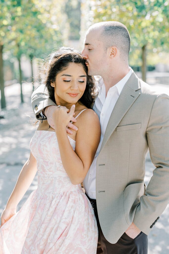 Elegant fall Longwood Gardens engagement portrait of Andrea and Rich framed by golden trees and classic stone architecture.