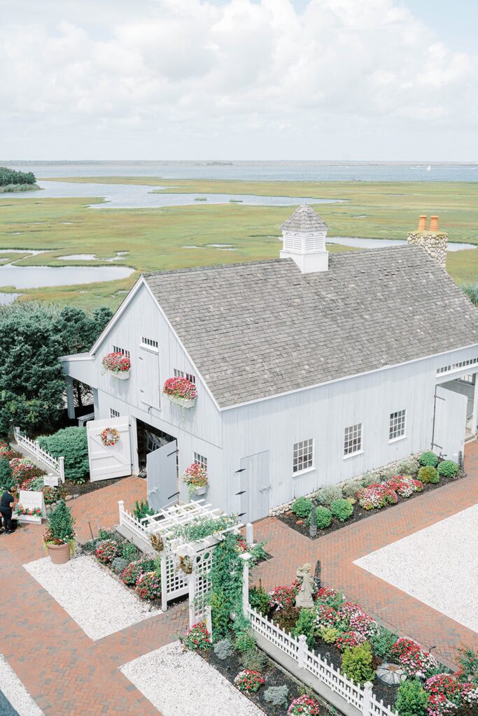 Exterior of Bonnet Island Estate barn and chapel with summer florals and blue coastal sky.