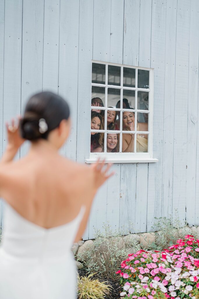 Bride with bridesmaids in vibrant coral and pink dresses at New Jersey wedding