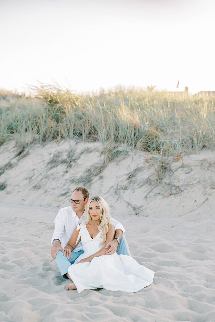 New Jersey beach engagement couple embracing with water view background