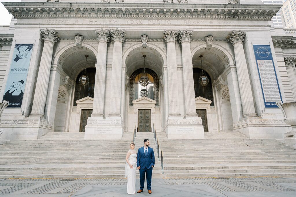 Stefanie leaning into Giovanni on the grand marble steps of the New York Public Library, NYC engagement portrait.