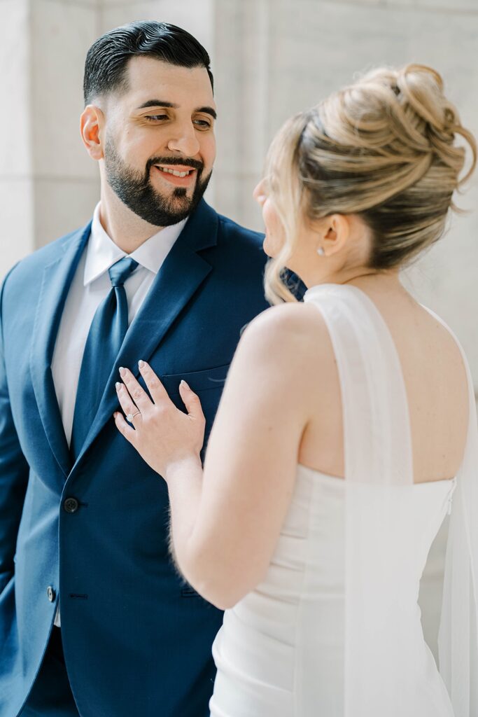 Close detail of Stefanie’s engagement ring held against the textured stone of New York Public Library architecture
