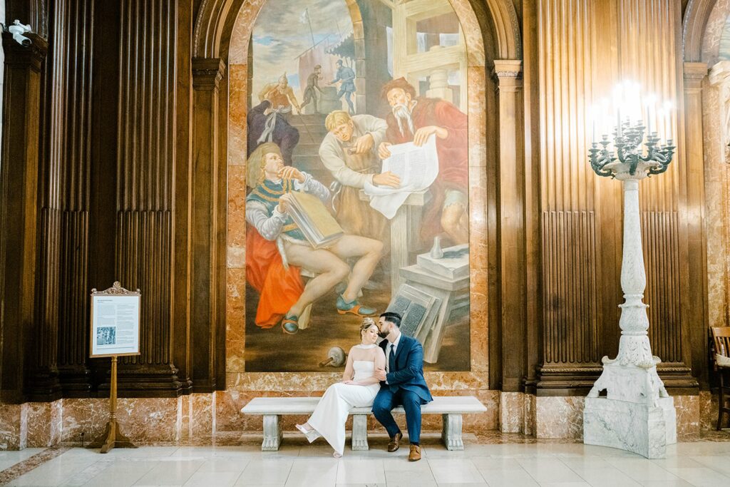 Wide engagement portrait of Stefanie and Giovanni with the New York Public Library’s grand facade and NYC streets in the background.